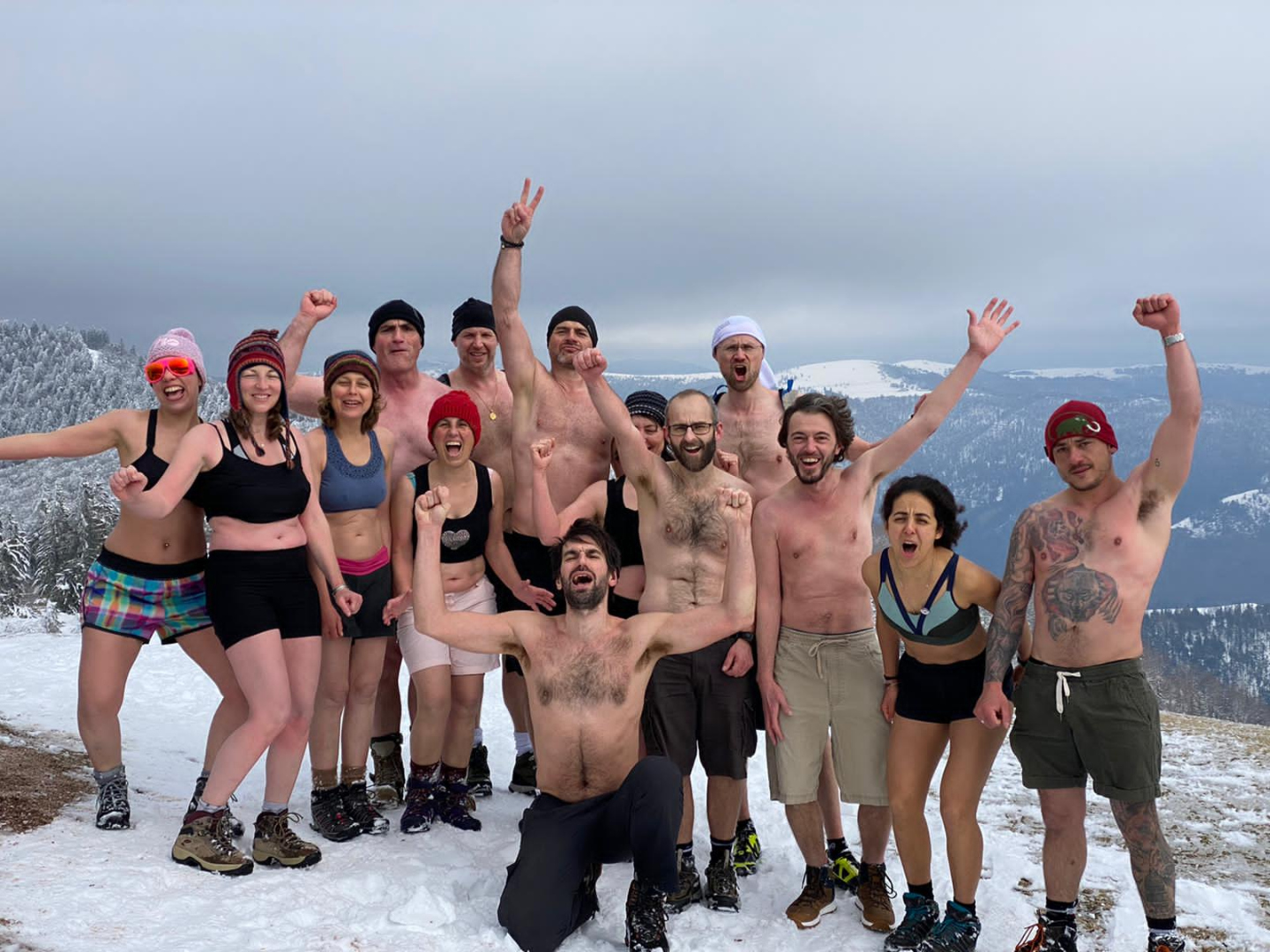 Une équipe réunie dans la neige, bras levés, après une expérience partagée